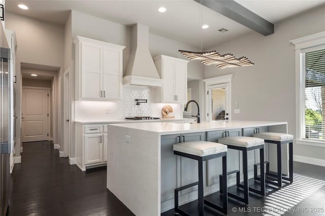 10616 N 81st E Pl, Owasso, OK 74055 - kitchen featuring premium range hood, light countertops, backsplash, white cabinets, and recessed lighting