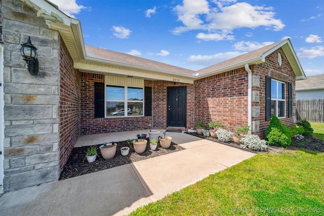 doorway to property with brick siding, roof with shingles, and covered porch