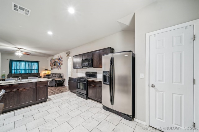 kitchen with black appliances, a sink, open floor plan, dark brown cabinets, and light countertops