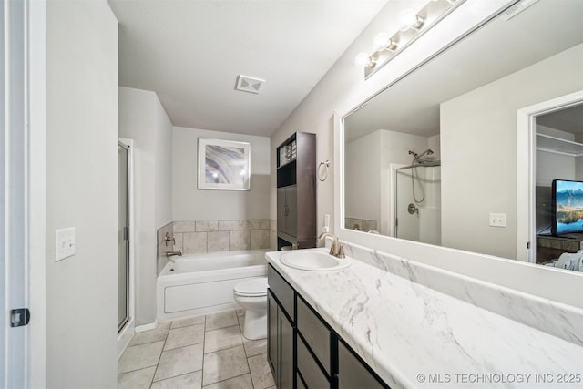 bathroom with a shower stall, vanity, and a garden tub