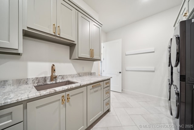 8499 S Timber Wolf Dr, Broken Arrow, OK 74014 - kitchen featuring a sink, light stone counters, gray cabinets, baseboards, and light tile patterned flooring