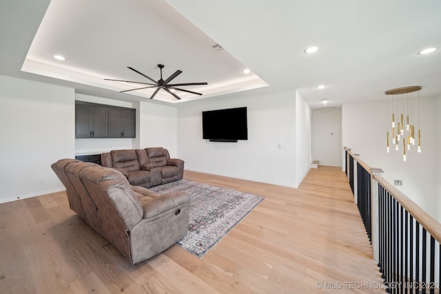 8499 S Timber Wolf Dr, Broken Arrow, OK 74014 - living area featuring a ceiling fan, light wood finished floors, a tray ceiling, recessed lighting, and baseboards