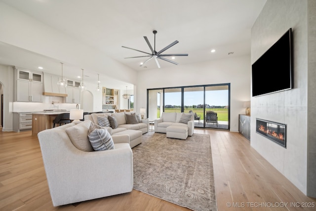 8499 S Timber Wolf Dr, Broken Arrow, OK 74014 - living area with a fireplace, a ceiling fan, recessed lighting, and light wood finished floors