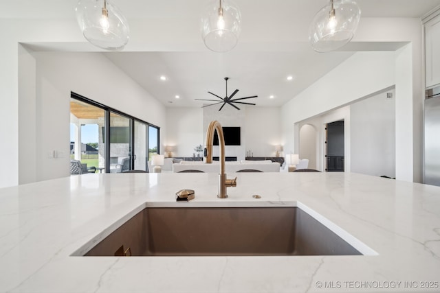 8499 S Timber Wolf Dr, Broken Arrow, OK 74014 - kitchen featuring a sink, open floor plan, light stone counters, recessed lighting, and pendant lighting