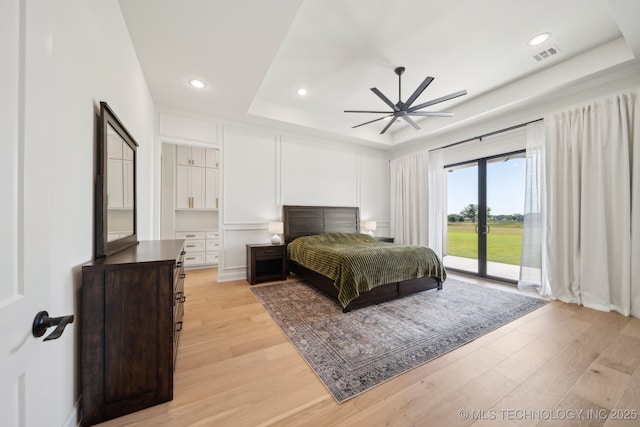 8499 S Timber Wolf Dr, Broken Arrow, OK 74014 - bedroom featuring a raised ceiling, access to outside, light wood-type flooring, recessed lighting, and a ceiling fan