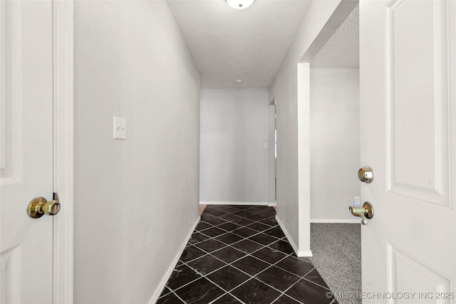 8508 E 123rd St S, Bixby, OK 74008 - corridor with dark tile patterned flooring, baseboards, and a textured ceiling