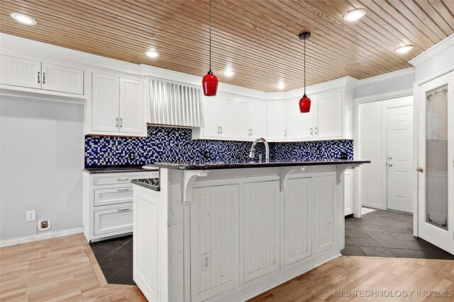 8508 E 123rd St S, Bixby, OK 74008 - kitchen featuring dark countertops, white cabinetry, a kitchen bar, recessed lighting, and decorative light fixtures