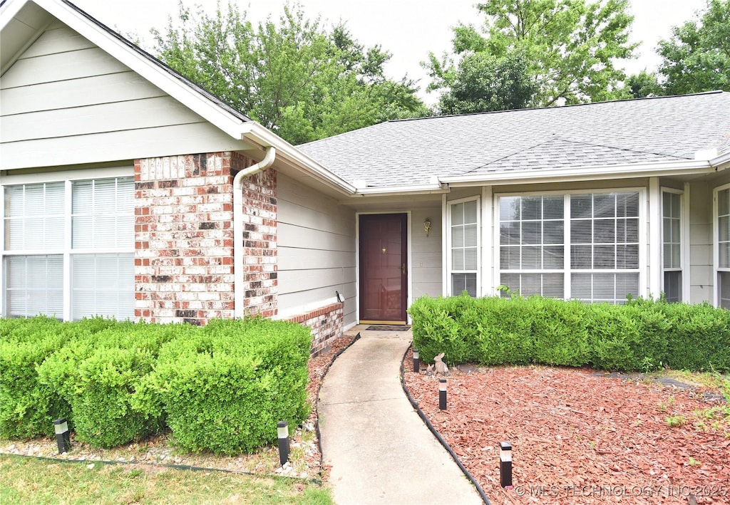 9905 E 117th Pl, Bixby, OK 74008 - property entrance with roof with shingles and brick siding