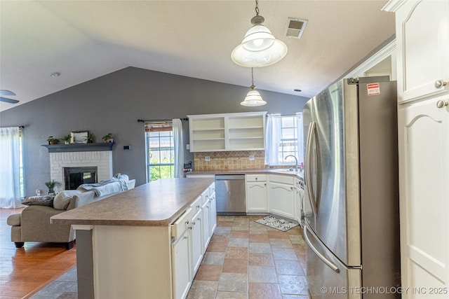 11636 S 102nd E Ave, Bixby, OK 74008 - kitchen with stainless steel appliances, vaulted ceiling, open shelves, a sink, and white cabinetry