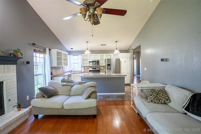 11636 S 102nd E Ave, Bixby, OK 74008 - living area featuring high vaulted ceiling, ceiling fan, wood finished floors, a fireplace, and baseboards