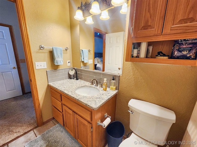 35824 S Talon Dr, Cookson, OK 74427 - bathroom featuring a textured wall, tile patterned flooring, toilet, vanity, and backsplash