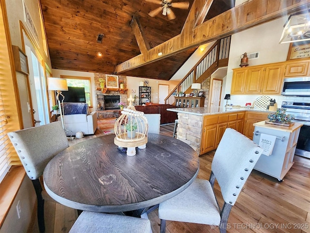 35824 S Talon Dr, Cookson, OK 74427 - dining room featuring a fireplace, stairway, high vaulted ceiling, light wood finished floors, and ceiling fan