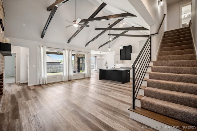 2044 E 138th Pl S, Bixby, OK 74008 - unfurnished living room with high vaulted ceiling, stairs, beam ceiling, ceiling fan, and a chandelier