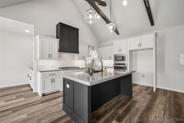 2044 E 138th Pl S, Bixby, OK 74008 - kitchen featuring appliances with stainless steel finishes, high vaulted ceiling, white cabinets, backsplash, and a kitchen island with sink