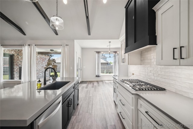 2044 E 138th Pl S, Bixby, OK 74008 - kitchen with a sink, stainless steel appliances, tasteful backsplash, light wood-style floors, and a kitchen island with sink