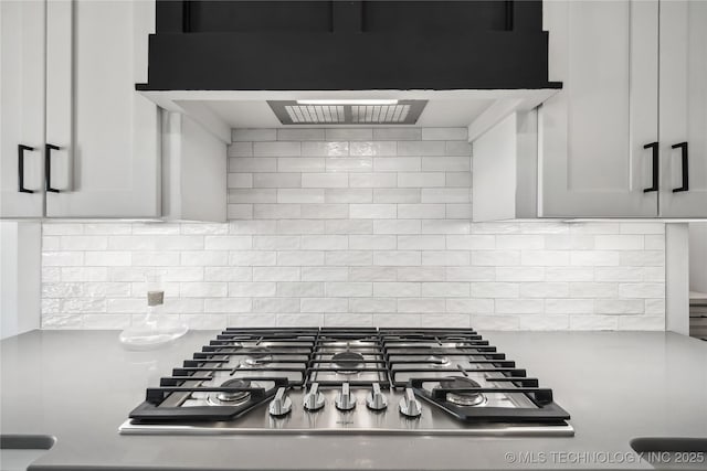 2044 E 138th Pl S, Bixby, OK 74008 - kitchen view of stainless steel gas cooktop, under cabinet range hood, decorative backsplash, and light countertops