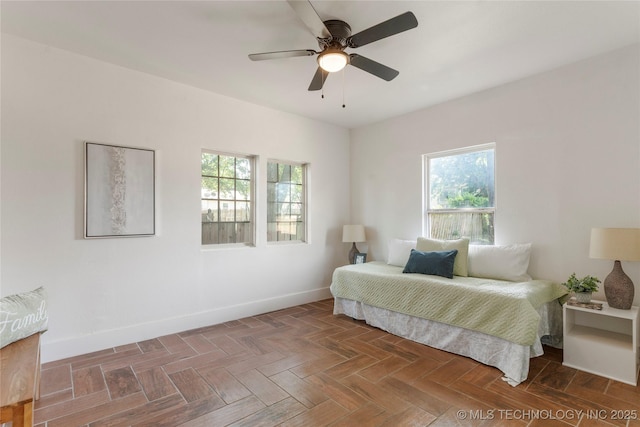 bedroom featuring multiple windows, baseboards, and ceiling fan