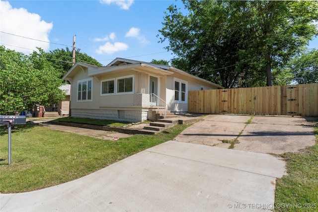 bungalow-style home featuring a gate and concrete driveway