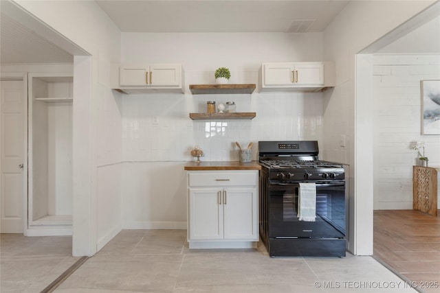 kitchen featuring black gas stove, white cabinetry, decorative backsplash, and open shelves
