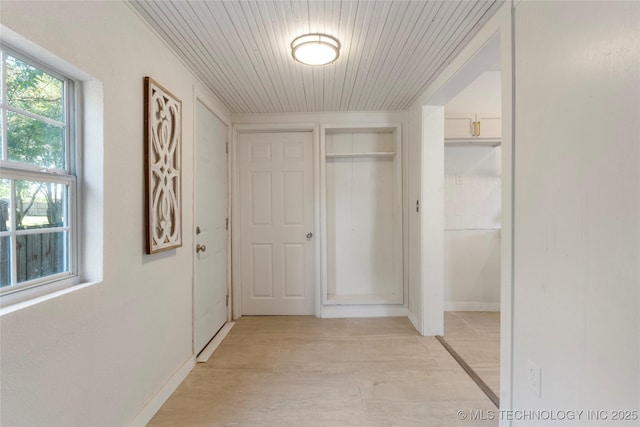 hallway featuring baseboards and wood ceiling