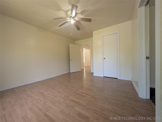 unfurnished bedroom featuring light wood-style floors, baseboards, and a ceiling fan