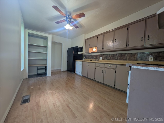 kitchen featuring a ceiling fan, white dishwasher, light wood finished floors, baseboards, and freestanding refrigerator
