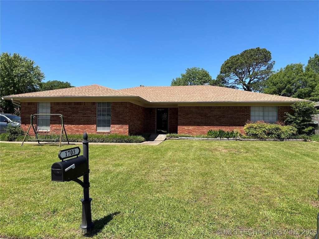 ranch-style house with brick siding and a front yard