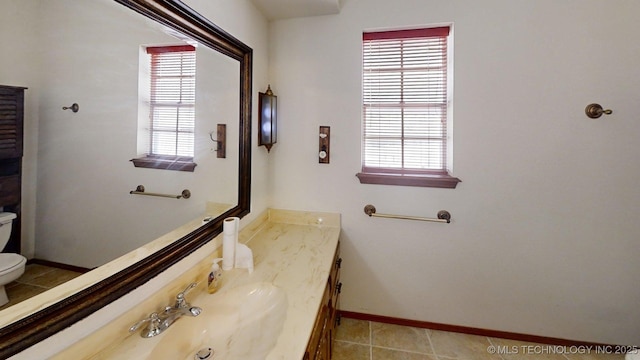1703 Vaden Ln, Ardmore, OK 73401 - half bath featuring toilet, plenty of natural light, vanity, and baseboards