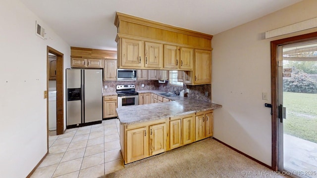 1703 Vaden Ln, Ardmore, OK 73401 - kitchen featuring appliances with stainless steel finishes, backsplash, a sink, a peninsula, and light brown cabinetry