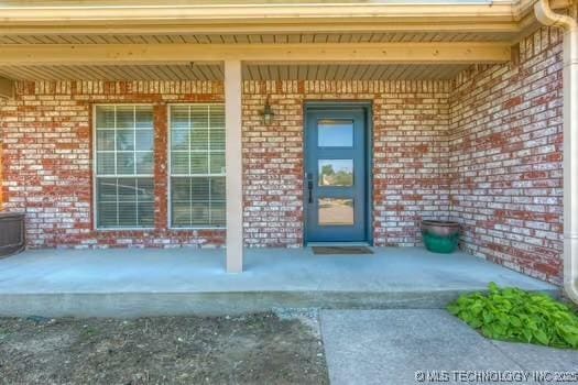 619 S Magnolia Pl, Broken Arrow, OK 74012 - view of exterior entry with a porch and brick siding