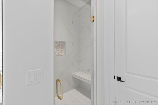 bathroom featuring a marble finish shower