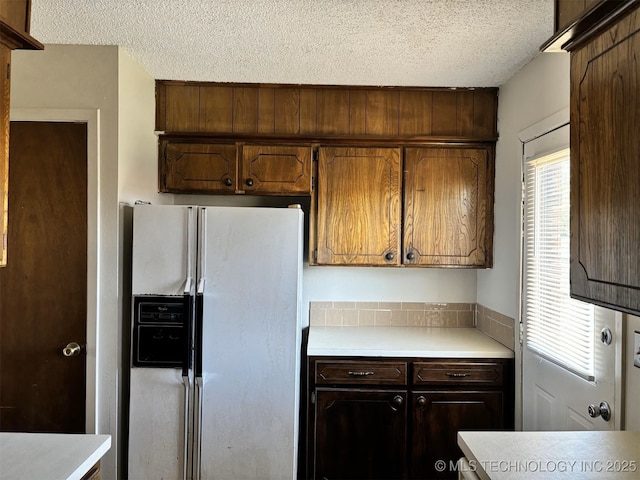 1612 Rustic Dr, Ardmore, OK 73401 - kitchen featuring white fridge with ice dispenser, a textured ceiling, and light countertops