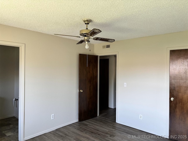 1612 Rustic Dr, Ardmore, OK 73401 - unfurnished bedroom with a textured ceiling, wood finished floors, baseboards, and ceiling fan