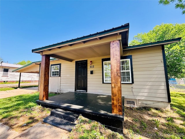 view of front of property featuring a porch and metal roof