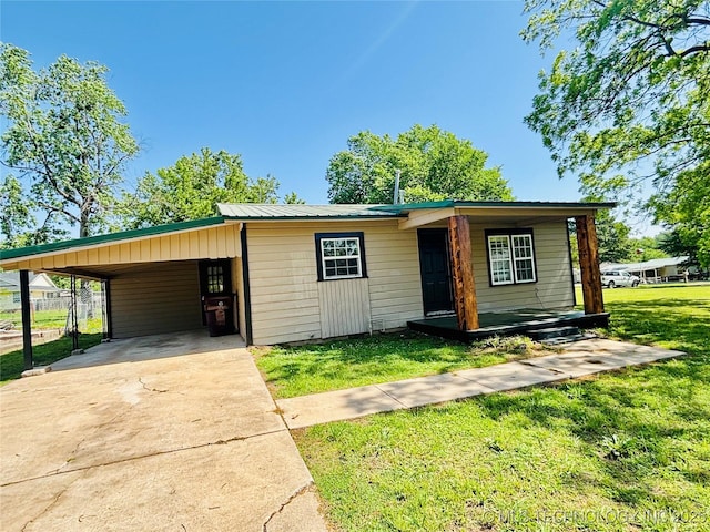 view of front of home with driveway, an attached carport, and metal roof