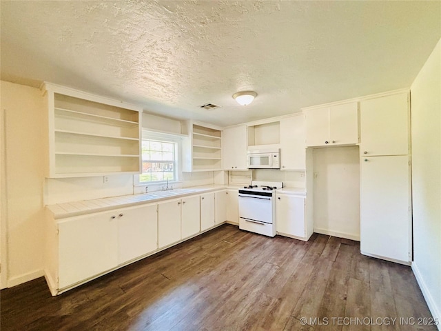 kitchen with white appliances, open shelves, a sink, dark wood finished floors, and a textured ceiling