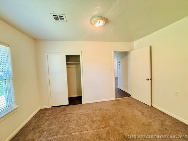 unfurnished bedroom featuring carpet flooring, baseboards, and a closet
