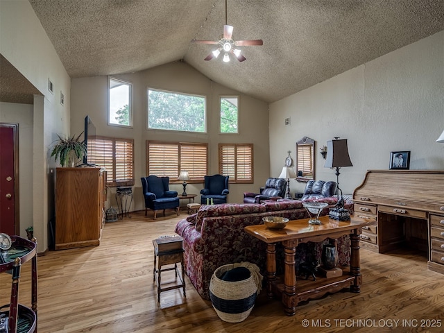 6551 S 41st St E, Muskogee, OK 74403 - living area featuring a ceiling fan, light wood finished floors, high vaulted ceiling, and a textured ceiling