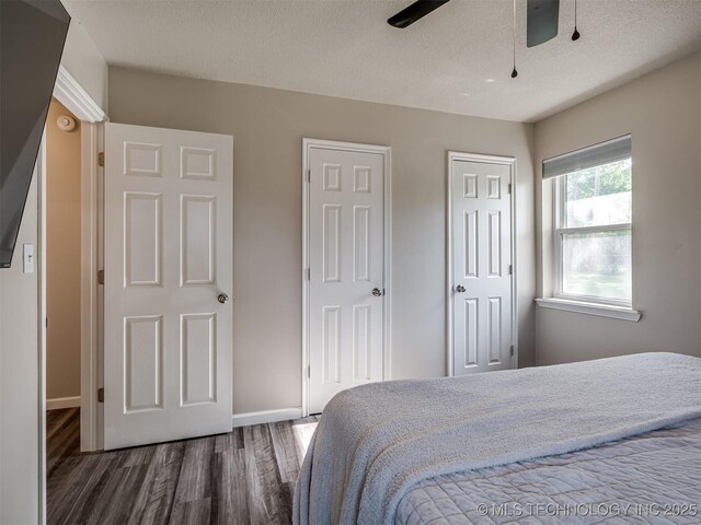 1149 N Hickory Pl, Broken Arrow, OK 74012 - bedroom featuring wood finished floors, multiple closets, a textured ceiling, baseboards, and ceiling fan