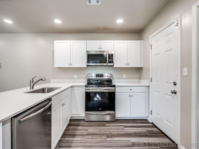 1149 N Hickory Pl, Broken Arrow, OK 74012 - kitchen featuring stainless steel appliances, a sink, white cabinetry, dark wood finished floors, and recessed lighting