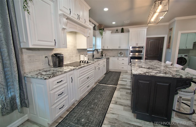 110 W Zachry Ln, Stigler, OK 74462 - kitchen with washer / dryer, stainless steel appliances, crown molding, white cabinetry, and a center island