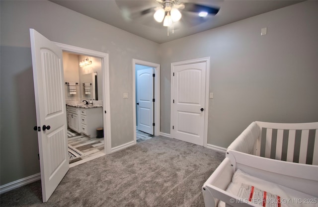110 W Zachry Ln, Stigler, OK 74462 - bedroom with carpet floors, baseboards, ensuite bathroom, a ceiling fan, and a sink