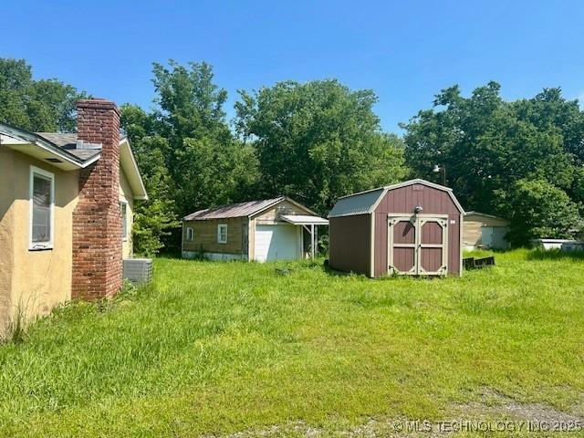 32767 S 4220th Rd, Inola, OK 74036 - view of grassy yard with a storage unit, an outbuilding, and central AC
