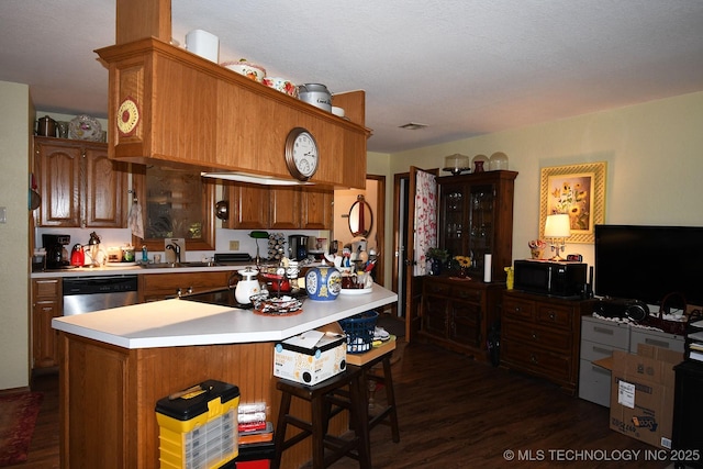 7457 S 105th St E, Braggs, OK 74423 - kitchen with light countertops, dark wood finished floors, dishwasher, brown cabinets, and a kitchen breakfast bar