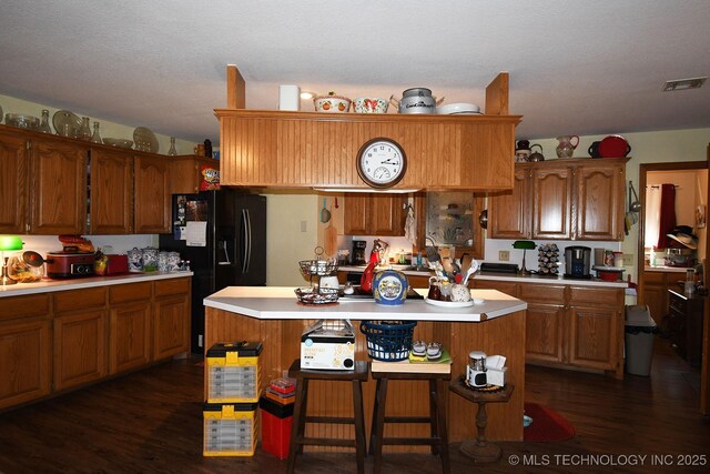 7457 S 105th St E, Braggs, OK 74423 - kitchen with light countertops, dark wood finished floors, brown cabinets, and a center island