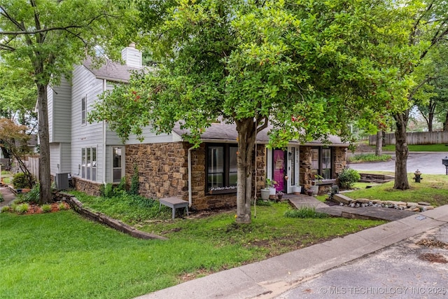 6315 E 98th Pl, Tulsa, OK 74137 - view of front of property featuring stone siding, cooling unit, a chimney, and roof with shingles