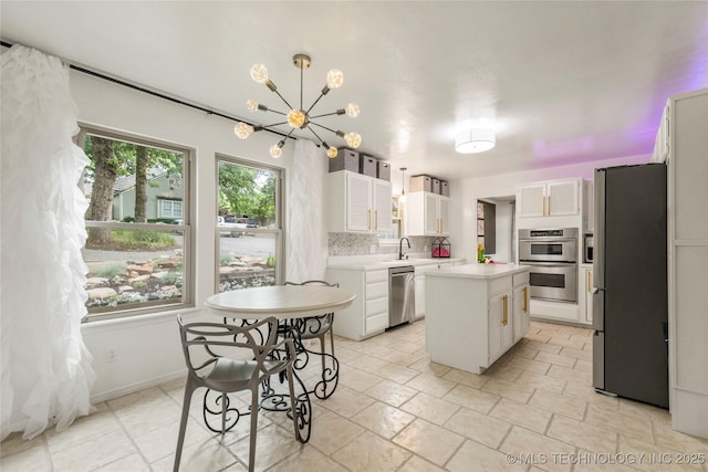 6315 E 98th Pl, Tulsa, OK 74137 - kitchen with appliances with stainless steel finishes, light countertops, a kitchen island, a chandelier, and white cabinets