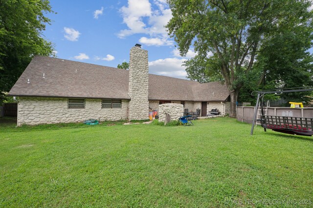 17711 E Archer St, Catoosa, OK 74015 - rear view of house with stone siding, a chimney, a wooden deck, and roof with shingles