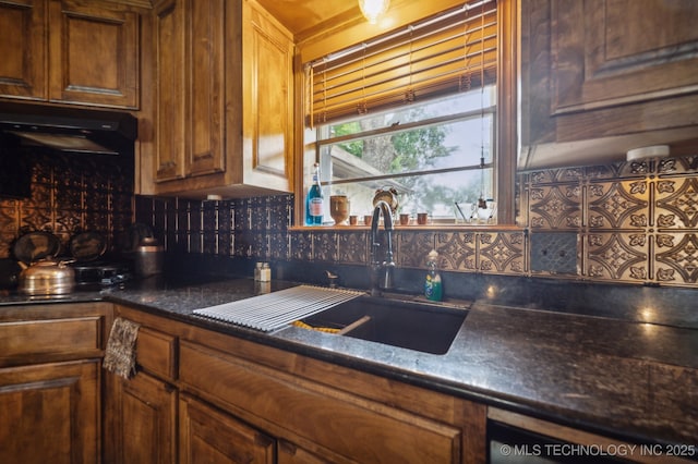 17711 E Archer St, Catoosa, OK 74015 - kitchen with a sink, dark countertops, decorative backsplash, under cabinet range hood, and brown cabinetry