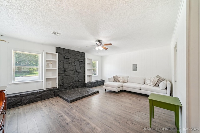 28505 E 139th St S, Coweta, OK 74429 - living area with ceiling fan, a textured ceiling, wood finished floors, built in features, and electric panel